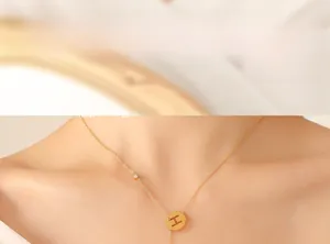 Close-up of 18k gold plated Y-shaped necklace with hollow letter H and zircon stone
