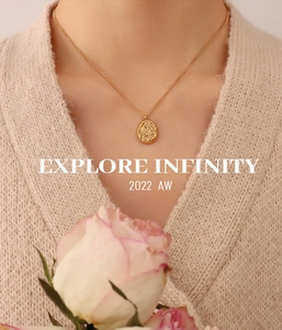 Detail of gold-plated irregular texture pendant necklace worn with a knit sweater