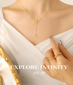 Detail of 18k gold plated Y-shaped tassel necklace with zircon and alphabet pendant