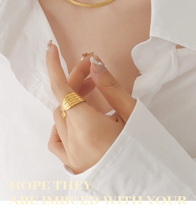 Close-up of 18K gold plated ribbed ring and snake chain necklace set on a model