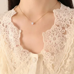 Minimalist gold clavicle necklace with zircon pendant worn on a model with lace top
