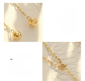 Detail of 18K gold plated titanium steel necklace with faceted ball and adjustable clasp