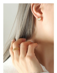 Detail of heart stud earrings with shell inlay and double-row gold chain ring