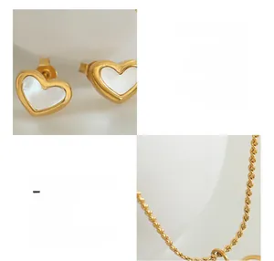 Detail of white shell heart earrings in 18K gold plated stainless steel finish