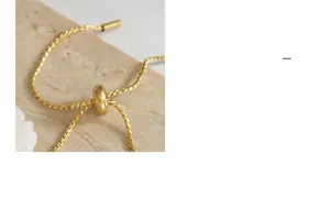 Detailed view of the gold-toned slider bead and fine woven chain jewelry closure