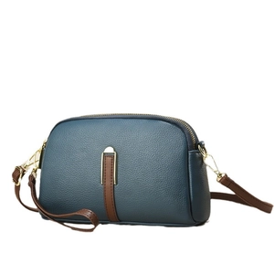 Blue-grey litchi grain leather crossbody bag with brown straps and U-shaped metal accent