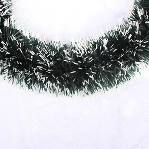 Macro detail of lush Christmas garland with frosted white tips on dense green PVC branches
