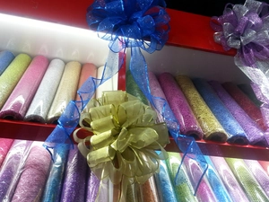 Détail de nœuds de Noël scintillants de 25cm en bleu et or sur des étagères de vente