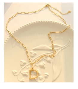 Detalle del colgante letra D bañado en oro 18K y cadena con el sello K18