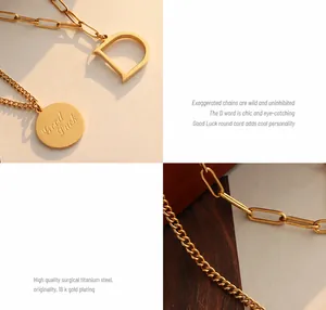 Detalle macro del colgante letra D chapado en oro 18K y etiqueta Good Luck en doble cadena