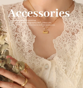 Close-up of golden lock necklace and butterfly ring set on a model with lace details