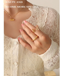 Detail of 18K gold plated butterfly ring and pendant on model in white lace top