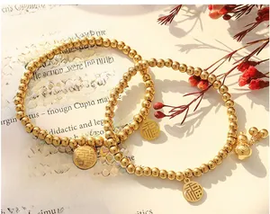 Detail von 18K vergoldeten Perlenarmbändern mit chinesischen Glücksanhängern und Kürbis