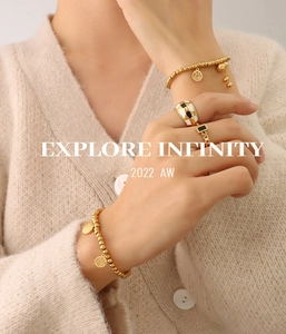 Nahaufnahme von Goldperlenarmbändern mit Fu- und Xi-Anhänger und Emaille-Ringen
