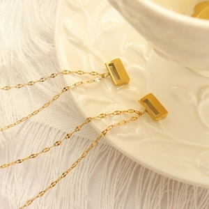 Minimalist 18K gold plated titanium steel necklace with hollow rectangle pendant on ceramic