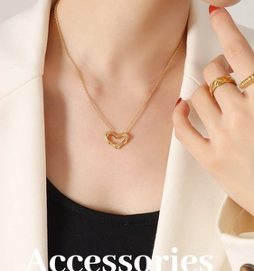 Detail of a liquid metal texture heart pendant necklace in gold on a model