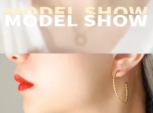Détail de boucles d'oreilles créoles torsadées dorées avec finition spirale texturée