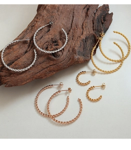 Vue détaillée des créoles torsadées en finitions or, argent et or rose multi-tailles