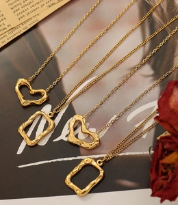Detail view of irregular heart and rectangle gold pendants on a vintage magazine page