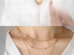 Close-up of a layered gold necklace with circular beads on a model's collarbone
