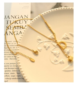 Macro shot of 18K gold plated D-letter pendant and square charm on a fine O-chain
