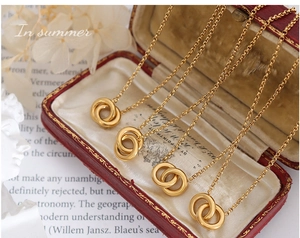 Detail view of interlocking double ring pendant in gold plating on a delicate chain