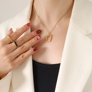 Minimalist gold titanium steel square heart necklace with lava texture on a model