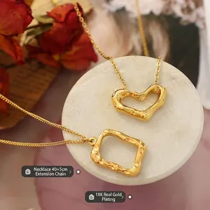 18K gold plated necklace with hammered geometric heart and square pendants on marble