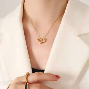 Gold minimalist heart pendant necklace with irregular wave edges on elegant female model