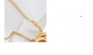 Macro detail of intertwined double rings on a delicate gold titanium steel chain necklace