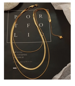 Détail d'un collier triple épaisseur doré avec maille serpent et pendentif en cœur