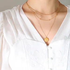 Three-layer 18K gold plated necklace with round pendant engraved Good Luck on model