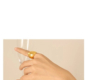 Close-up of a chunky 18K gold plated ring with a mirror-finish surface on a female hand