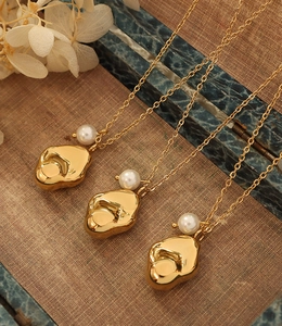 Detail of 18K gold plated fluid metal pendant with white pearl on fine chain