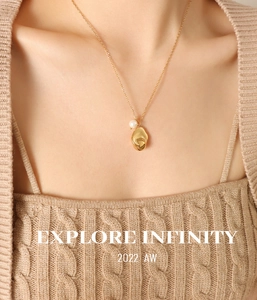 Detail of 18K gold-plated necklace with a fluid geometric pendant and white round pearl