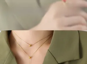 Close-up of golden double-layer beaded necklace worn on a green blazer outfit