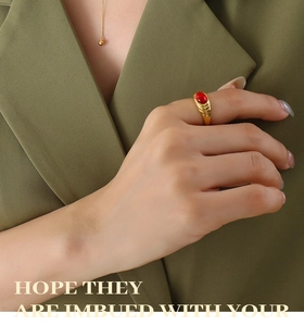 Detail of a vintage gold wide ring with red oval gemstone and textured band for women