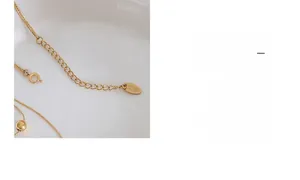 Detailed close-up of gold double-layered ball necklace with adjustable lobster clasp chain