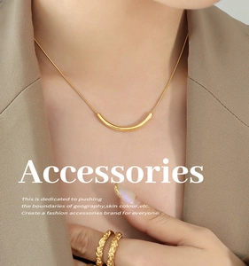 Detail of gold smile necklace and hammered rings set on professional model outfit