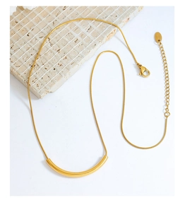 Close-up of gold-plated snake chain necklace with lobster clasp and adjustable tail chain