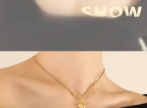 Close-up of golden heart pendant necklace on neck showing asymmetric chain design