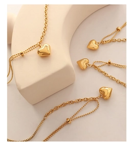 Detail of gold 3D heart pendant necklace with dual-layer O-chain and bead chain design
