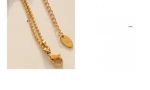 Detailed macro view of gold lobster clasp and K18 engraved tag on heart pendant necklace