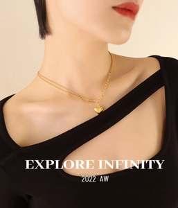 Close-up of golden heart pendant necklace with mixed chain links on female model