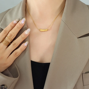 Minimalist gold titanium steel smile necklace and ring set worn on an elegant model