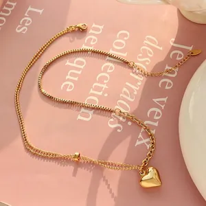 18K gold plated heart pendant necklace with mixed chain links on stylish background