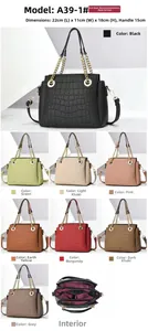 Detail view showing multi-compartment interior and chain handle of crocodile pattern tote