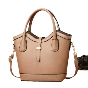 Minimalist tan stitched bucket bag with top handle and adjustable shoulder strap