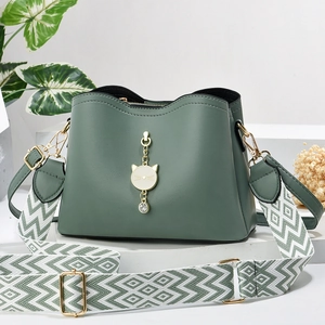Dark green leather multi-layer handbag with gold cat charm and woven shoulder strap