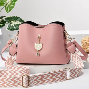 Pink PU leather handbag with cat charm and geometric patterned woven shoulder strap